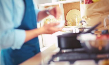 Adam ev mutfağında lezzetli ve sağlıklı yemekler hazırlıyor.