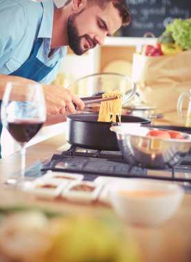 Adam ev mutfağında lezzetli ve sağlıklı yemekler hazırlıyor.