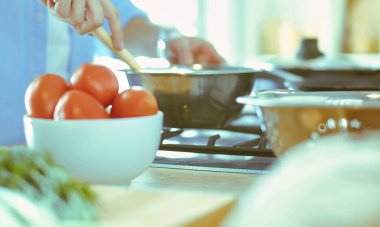 Adam ev mutfağında lezzetli ve sağlıklı yemekler hazırlıyor.