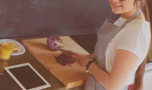 Giovane donna che utilizza un tablet per cucinare nella sua cucina — Foto Stock