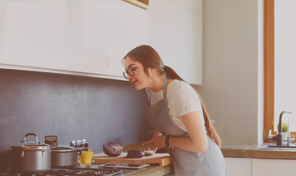 Fiatal nő használ egy tabletta számítógép főzni a konyhában — Stock Fotó