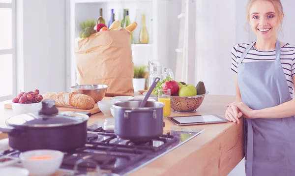 Schöne junge Frau kocht zu Hause in der Küche — Stockfoto