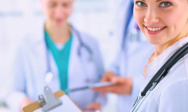 Atractiva doctora con carpeta delante del grupo médico —  Fotos de Stock