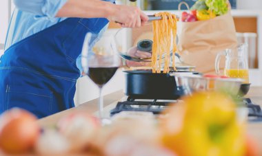 Adam ev mutfağında lezzetli ve sağlıklı yemekler hazırlıyor.