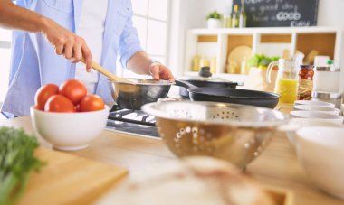 Adam ev mutfağında lezzetli ve sağlıklı yemekler hazırlıyor.