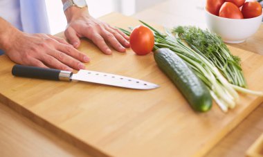 Adam ev mutfağında lezzetli ve sağlıklı yemekler hazırlıyor.