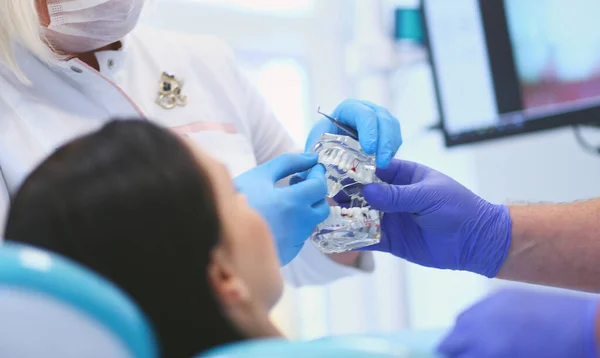 Médico dentista sênior em consultório odontológico conversando com paciente do sexo feminino e se preparando para o tratamento — Fotografia de Stock