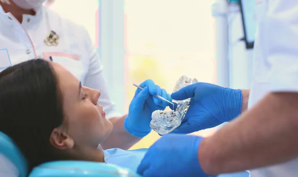 Diş kliniğinde duran gülümseyen bir dişçinin portresi. — Stok fotoğraf