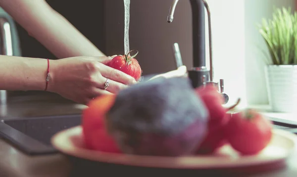 Frau wäscht Tomaten in Küchenspüle aus nächster Nähe — Stockfoto