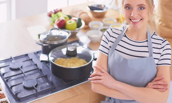 Giovane donna in piedi vicino alla scrivania in cucina — Foto Stock