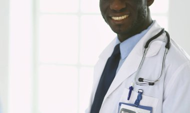 Tablet bilgisayarlı siyahi bir doktor hastanede bekliyor.