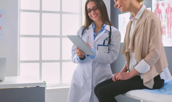 Médico e paciente discutindo algo enquanto se senta na mesa. Conceito de medicina e cuidados de saúde — Fotografia de Stock