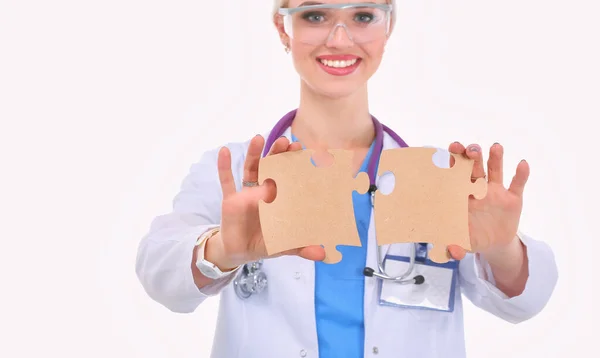 Woman doctor holding two connecting puzzle pieces — Stock Photo, Image