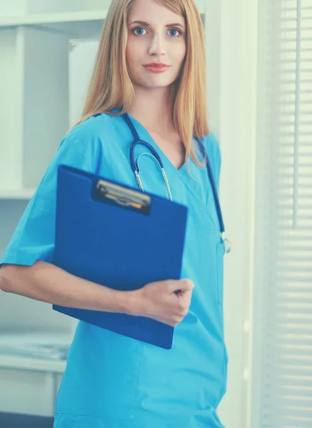 Portret van vrouwelijke arts met map in ziekenhuisgang — Stockfoto