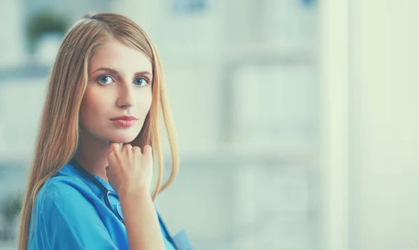 Doctor woman is standing in the near window — Stock Photo, Image