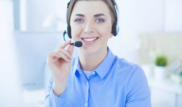 Ernstige mooie jonge vrouw die werkt als support telefoon operator met headset in het kantoor — Stockfoto