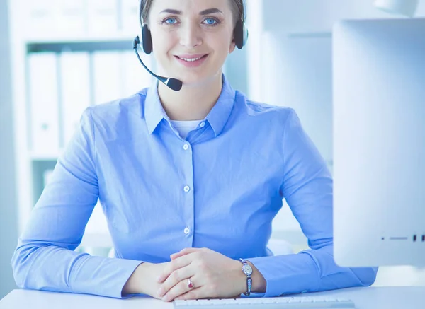 Mujer bastante joven y seria que trabaja como operador de telefonía de apoyo con auriculares en la oficina — Foto de Stock