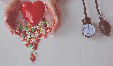 Masada kırmızı kalbi ve steteskopu olan kardiyolog.