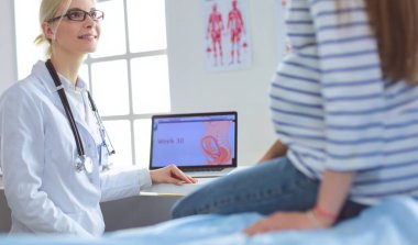 Hastanede doktorla gülümseyen güzel bir hamile kadın.