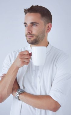 Bir fincan kahve ya da çay içen genç iş adamı.