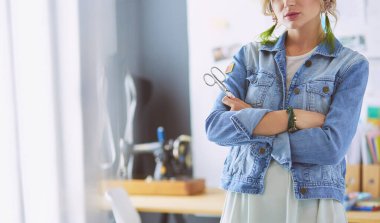 Moda tasarımcısı kadın stüdyoda tasarımları üzerinde çalışıyor.