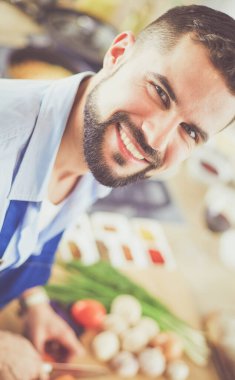 Adam ev mutfağında lezzetli ve sağlıklı yemekler hazırlıyor.