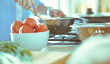 Adam ev mutfağında lezzetli ve sağlıklı yemekler hazırlıyor.