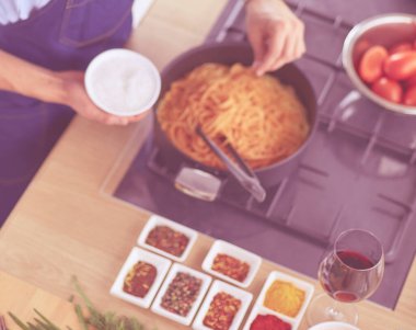 Adam ev mutfağında lezzetli ve sağlıklı yemekler hazırlıyor.