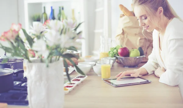 Hermosa joven usando una tableta digital en la cocina —  Fotos de Stock