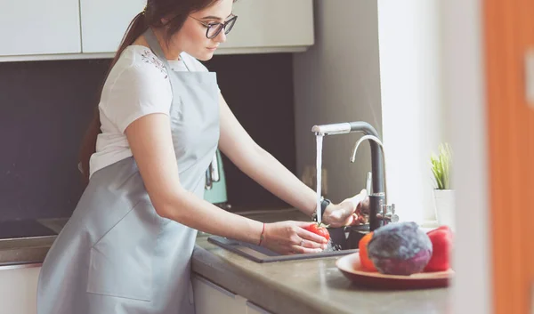 Mãos de mulher lavando legumes em sua cozinha — Fotografia de Stock