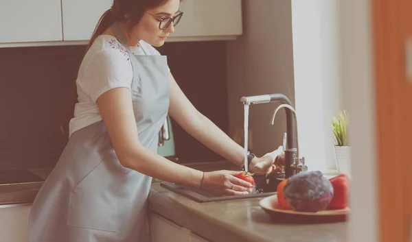 Manos de mujer lavando verduras en su cocina — Foto de Stock