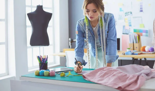 Mulher designer de moda trabalhando em seus projetos no estúdio — Fotografia de Stock