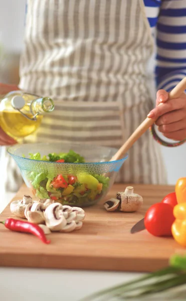 Mujer joven mezclando ensalada fresca — Foto de Stock