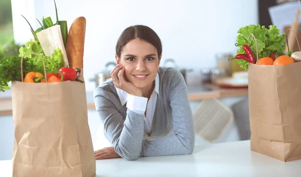 Portrait of a smiling woman cooking in her kitchen sitting — Stock Photo, Image