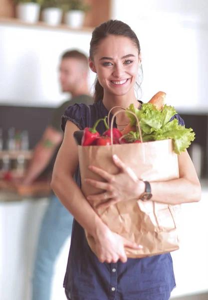 Jong stel in de keuken, vrouw met een zak boodschappen doen — Stockfoto