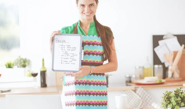 Giovane donna in grembiule sta cucinando in cucina — Foto Stock