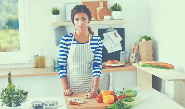 Jovem mulher cortando legumes na cozinha em casa — Fotografia de Stock