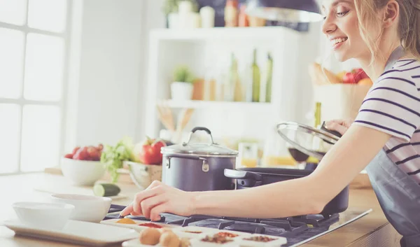 Schöne junge Frau kocht zu Hause in der Küche — Stockfoto