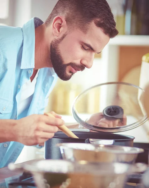 Homem seguindo receita em tablet digital e cozinhar comida saborosa e saudável na cozinha em casa — Fotografia de Stock