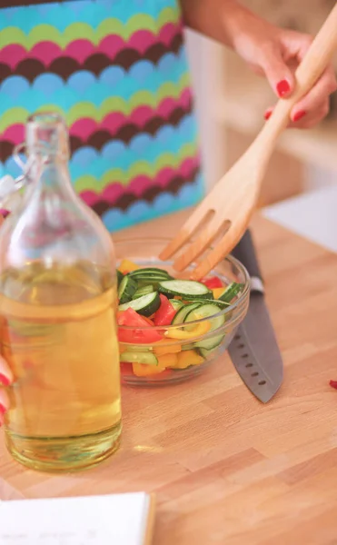 Glimlachende jonge vrouw mengen van verse salade — Stockfoto