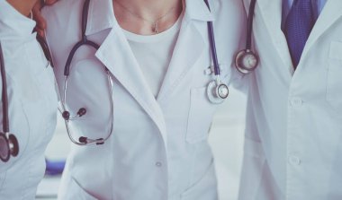 Birçok mutlu doktor motivasyon için el ele tutuşur.