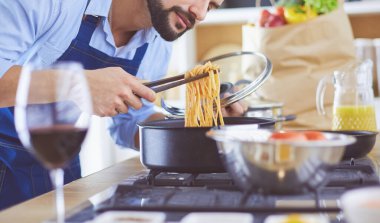 Adam ev mutfağında lezzetli ve sağlıklı yemekler hazırlıyor.