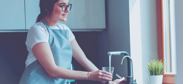 Vrouw die een glas water vult uit een roestvrijstalen kraan of kraan — Stockfoto