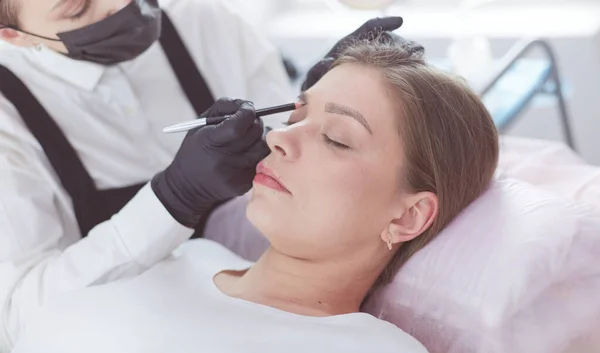 Cosmetologist applying permanent make up on eyebrows — Stock Photo, Image