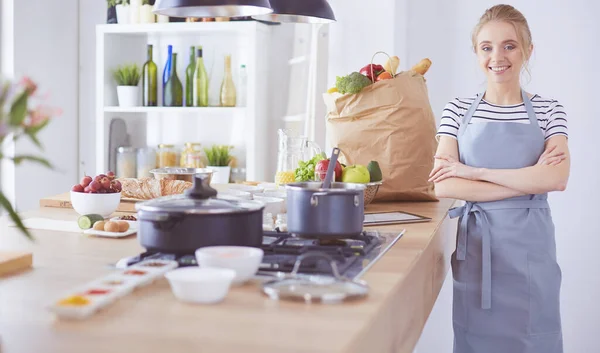 Schöne junge Frau kocht zu Hause in der Küche — Stockfoto