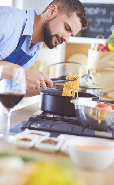 Uomo che prepara cibo delizioso e sano nella cucina di casa — Foto Stock