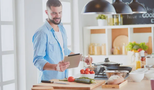 Mann folgt Rezept auf digitalem Tablet und kocht leckeres und gesundes Essen in der heimischen Küche — Stockfoto
