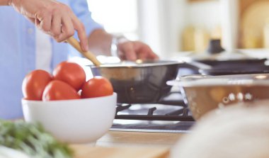 Adam ev mutfağında lezzetli ve sağlıklı yemekler hazırlıyor.