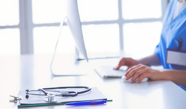 Beautiful young smiling female doctor sitting at the desk — Stock Photo, Image