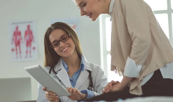 Doktorn och patienten diskuterar något när de sitter vid bordet. Medicin och hälsovård — Stockfoto